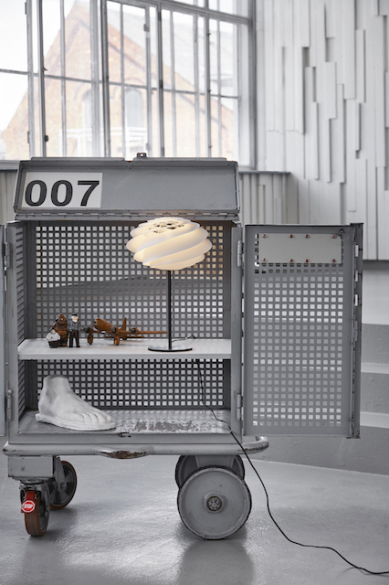 Swirl Tischleuchte von Le Klint auf einem Regal. Design Lampe mit spiralförmigem Lampenschirm.