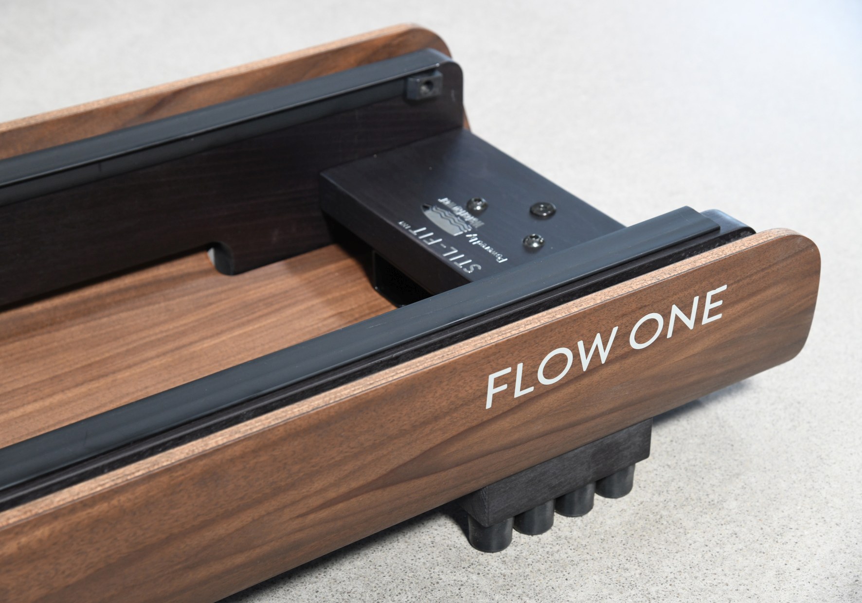 Detailaufnahme des Flow One Rudergeräts aus Holz mit schwarzem Rahmen und Füßen.