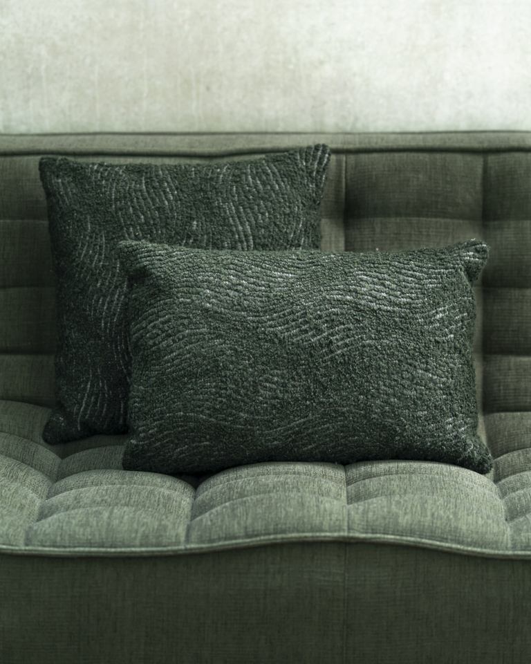 Zwei graue Ethnicraft Kissen mit gewebter Textur auf einem grauen Sofa, Dekokissen für Wohnzimmer.