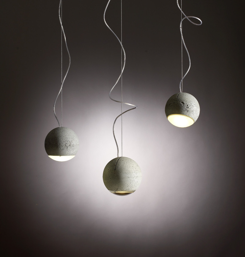 Trabant 2 Pendelleuchte von Tecnolumen: Drei moderne Hängelampen mit runden, grauen Betonschirmen und gewundenen Kabeln.