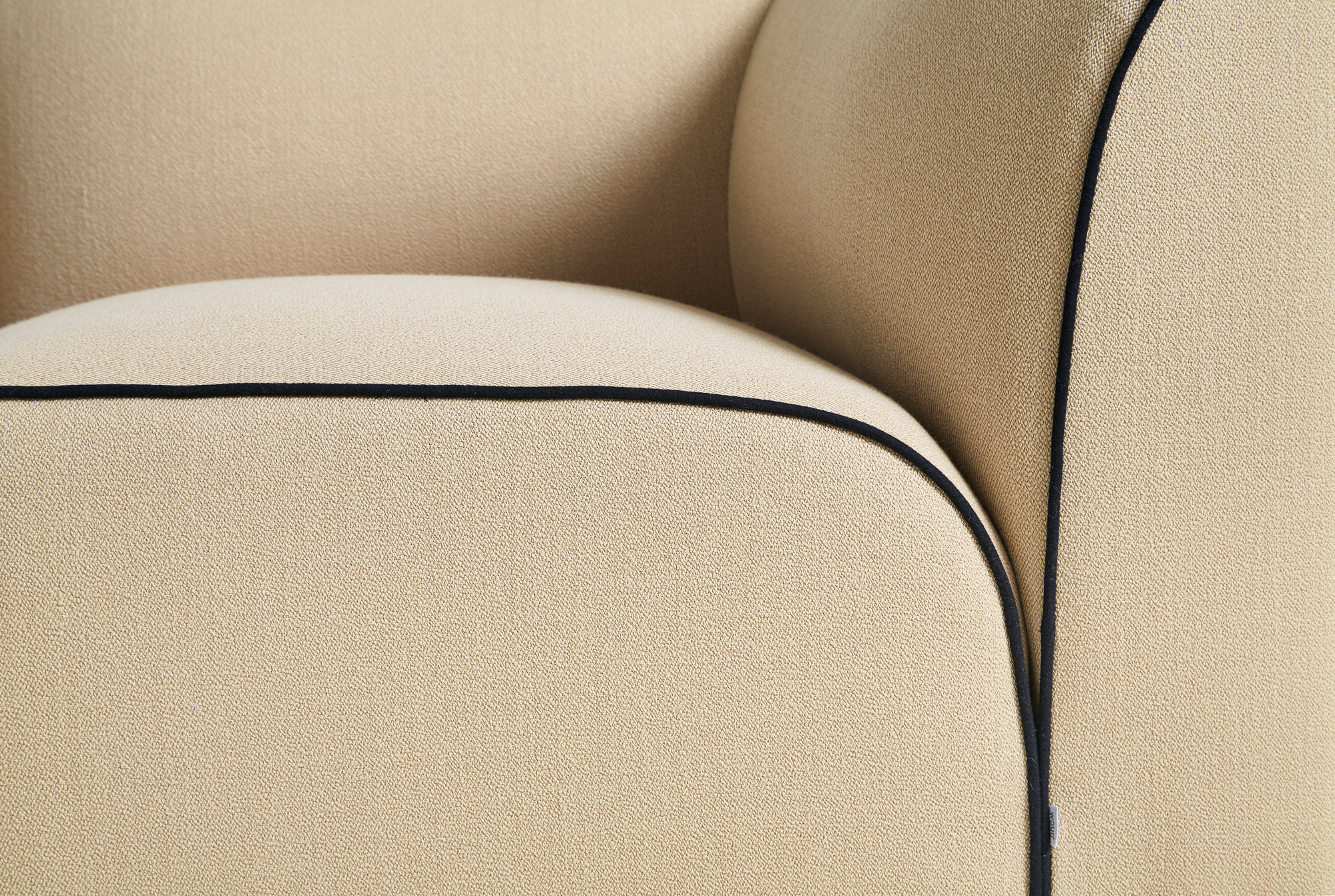 Detailaufnahme des Flora Sofas von Woud: Beige Polsterung mit schwarzer Paspelierung. Modulares Sofa für Wohnzimmer.