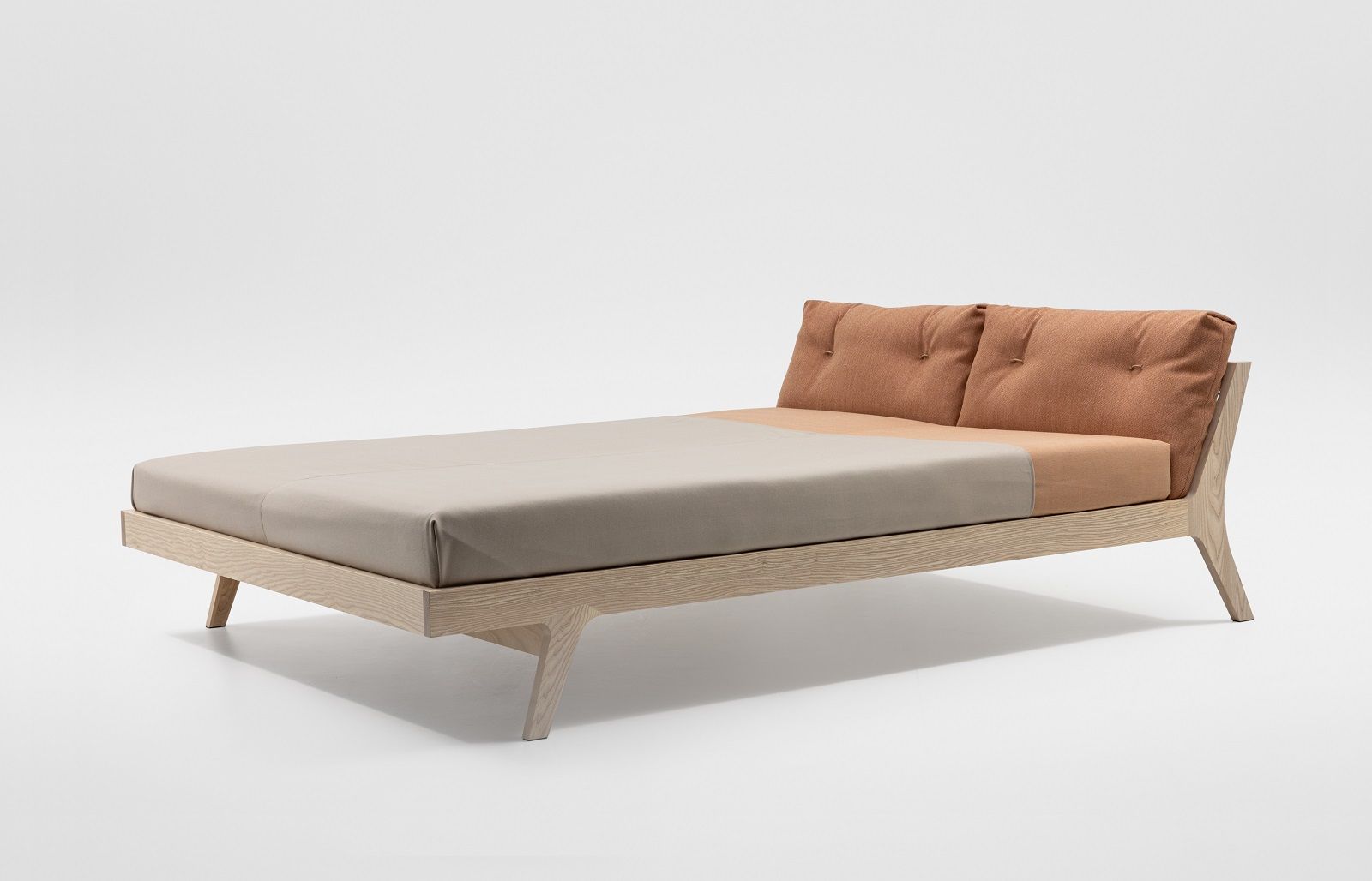 Mellow Bett aus Massivholz: Modernes Bettgestell mit hellen Bezügen und gepolstertem Kopfteil.