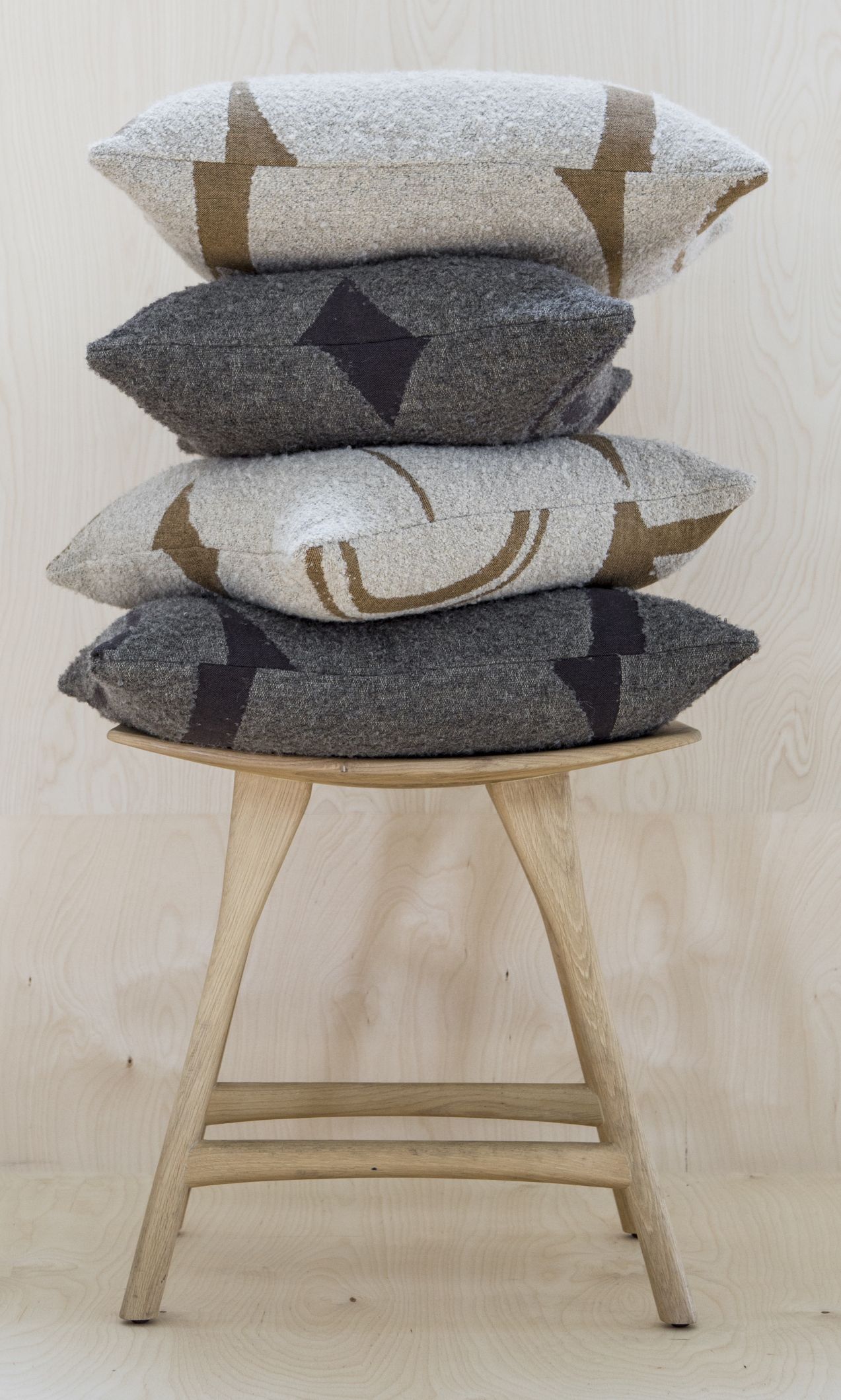 Osso Stuhl aus Eiche von Ethnicraft mit Kissenstapel in Grau und Beige.