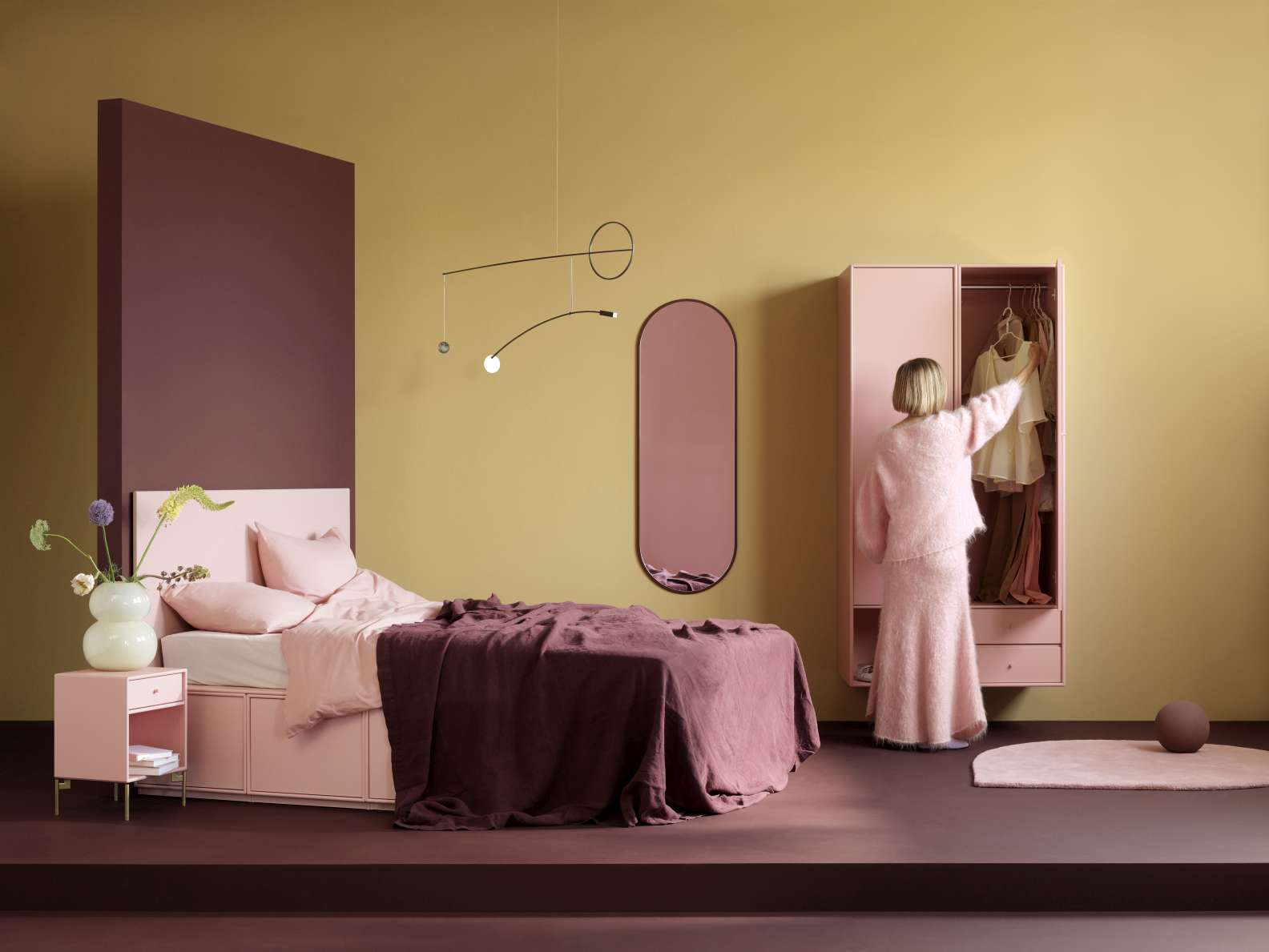 Ovale Montana Oyster Spiegel Figur im Schlafzimmer mit Bett und Kleiderschrank.