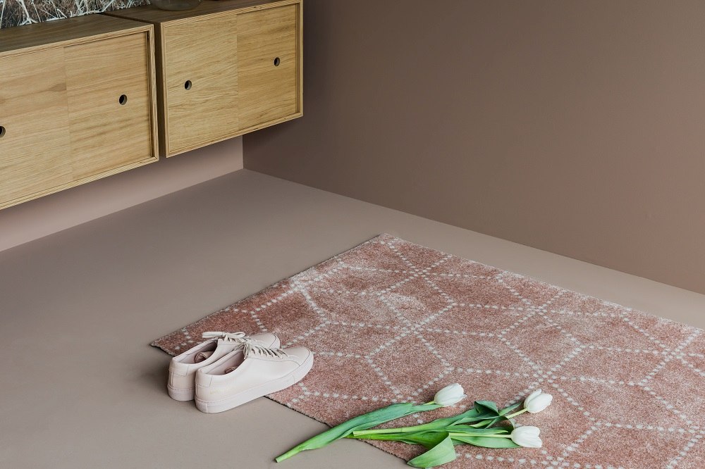 Hagl Heymat Fußmatte in Schwarz, 60x85 cm, mit Schuhen und Tulpen auf dem Boden.