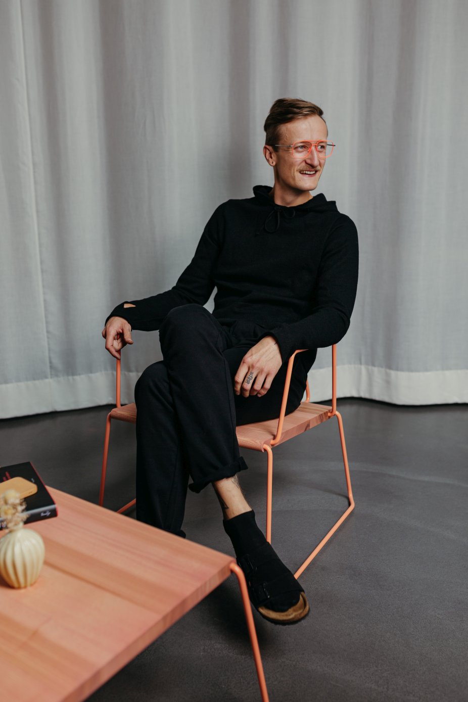 Mann sitzt entspannt im D:008 Loungechair von Fuchs & Habicht. Kohleschwarzer Sessel mit Armlehnen.