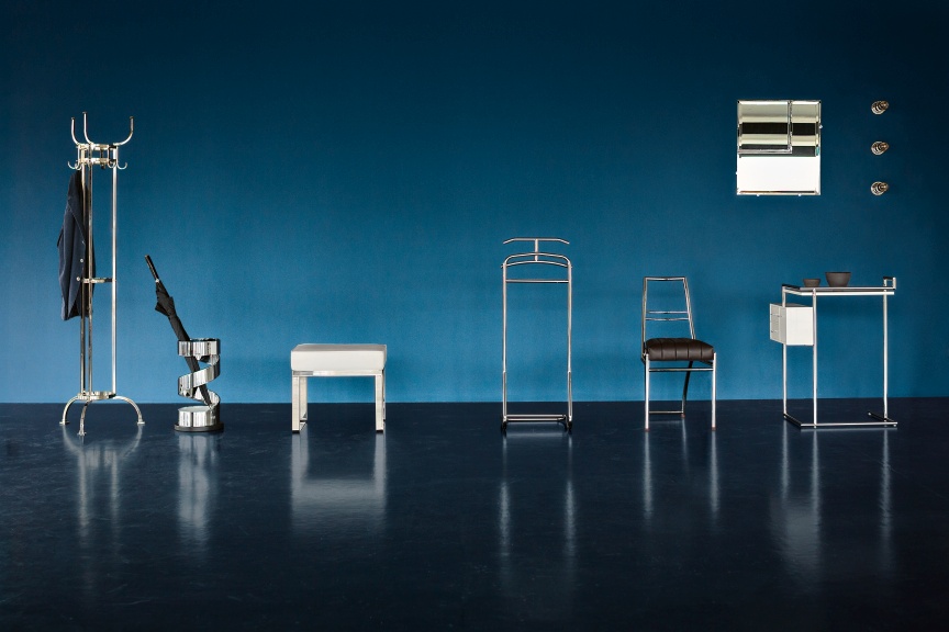 Nymphenburg Coat Stand Garderobenständer ClassiCon aus Nickel, mit weiteren Möbeln vor blauem Hintergrund.