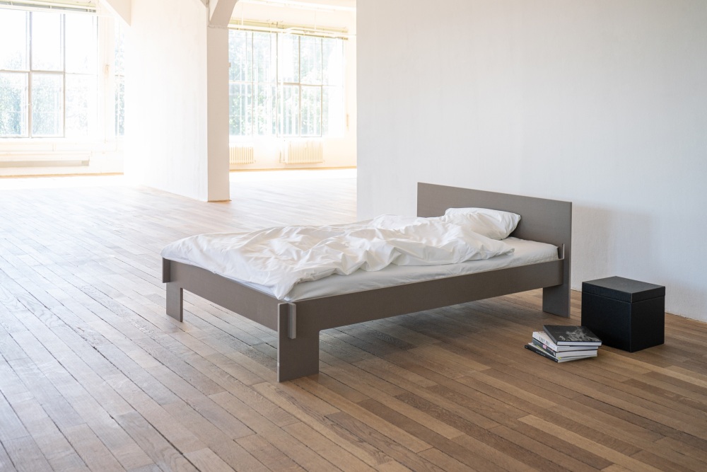 Schwarzes Siebenschläfer Bett 140 cm von Nils Holger Moormann mit Kopfteil und weißer Bettwäsche.