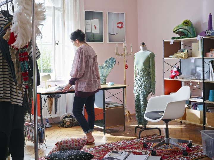 Weißer Eames Plastic Arm Chair PACC mit Sitzpolster von Vitra in einem kreativen Arbeitszimmer.