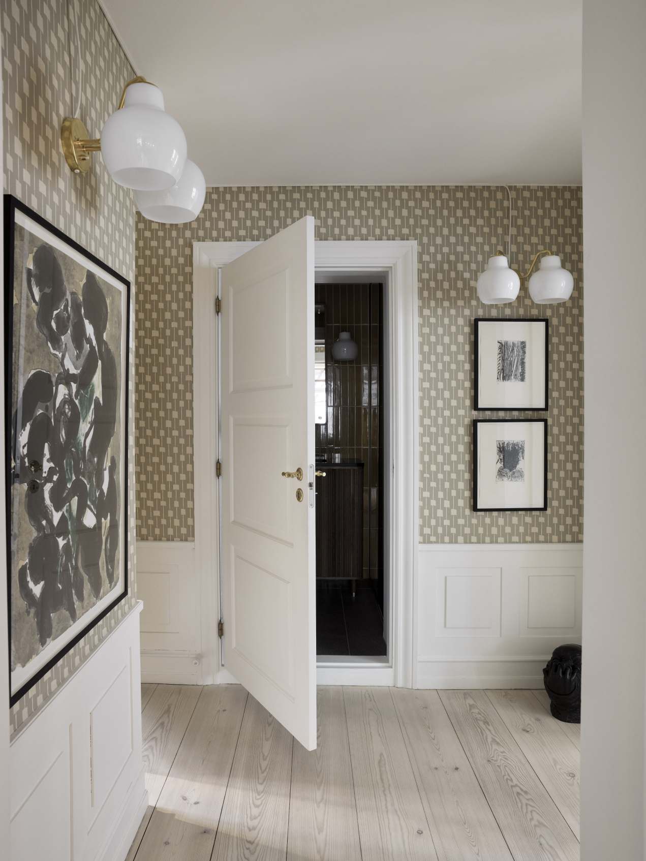 Flur mit VL Ring Crown Wandleuchten von Louis Poulsen, weißen Wänden und Holzboden.