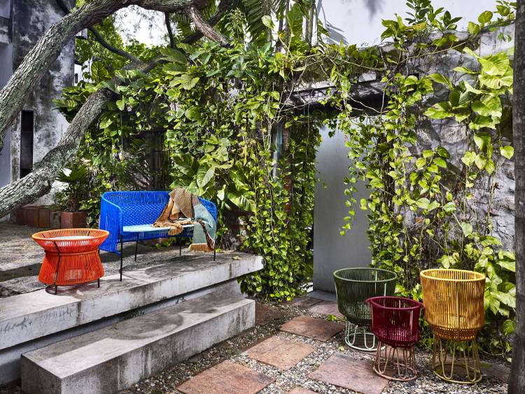 Caribe 2-Sitzer Outdoor Bank in Smaragdgrün mit farbigen Beistelltischen im Garten.