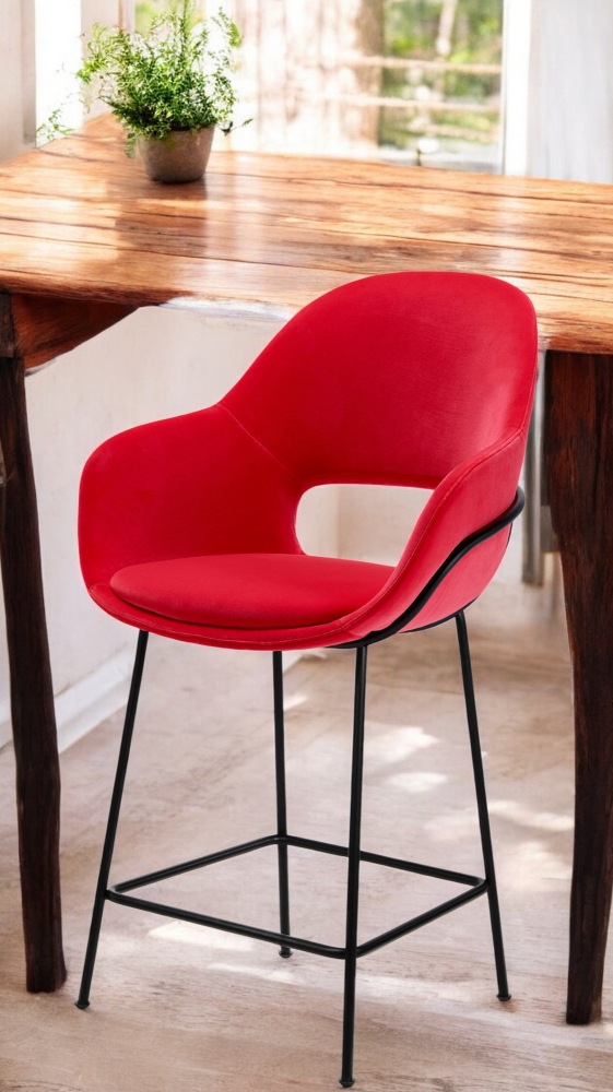 Roter Theia Barhocker von Freifrau Manufaktur mit Armlehne und schwarzem Metallgestell vor Holztisch.