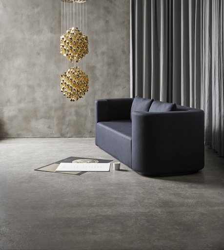 VP168 Verpan 3-Sitzer Sofa in Dunkelblau vor grauer Wand und goldener Hängelampe.