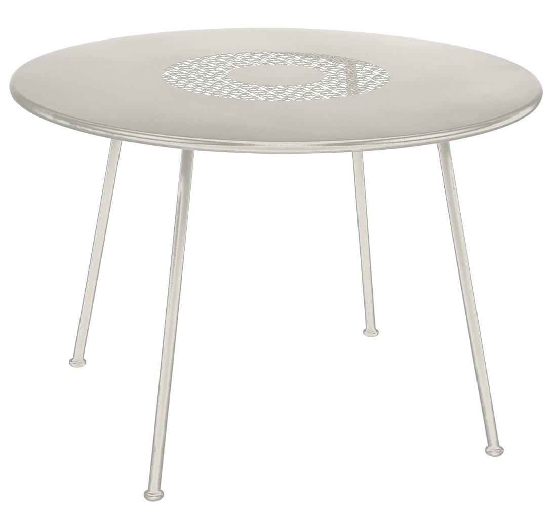 Runder, beiger Fermob Gartentisch Lorette mit filigranem Lochmuster im Tischblatt und drei Beinen.