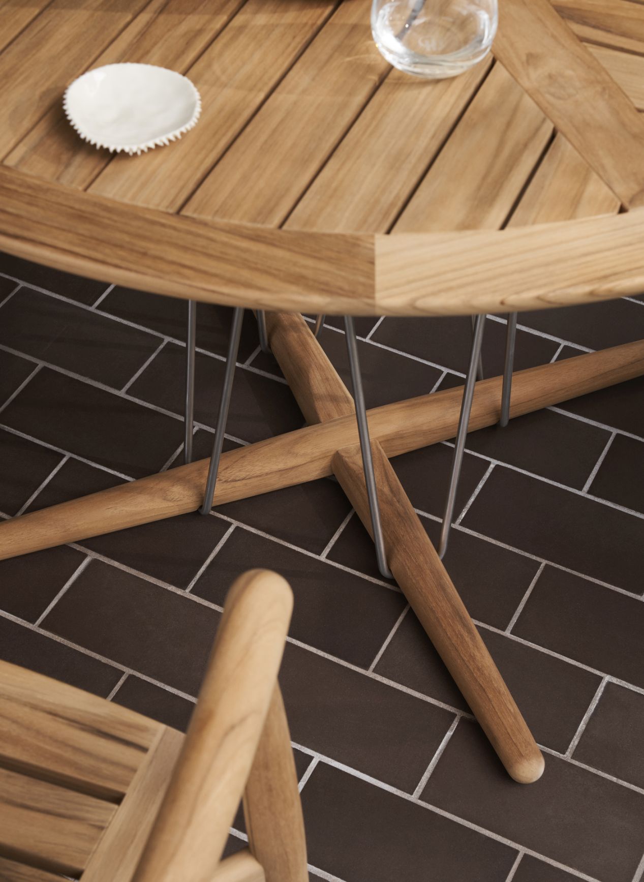 Detailaufnahme des E022 Embrace Outdoor Tischs von Carl Hansen & Søn, runder Teakholztisch für den Garten.