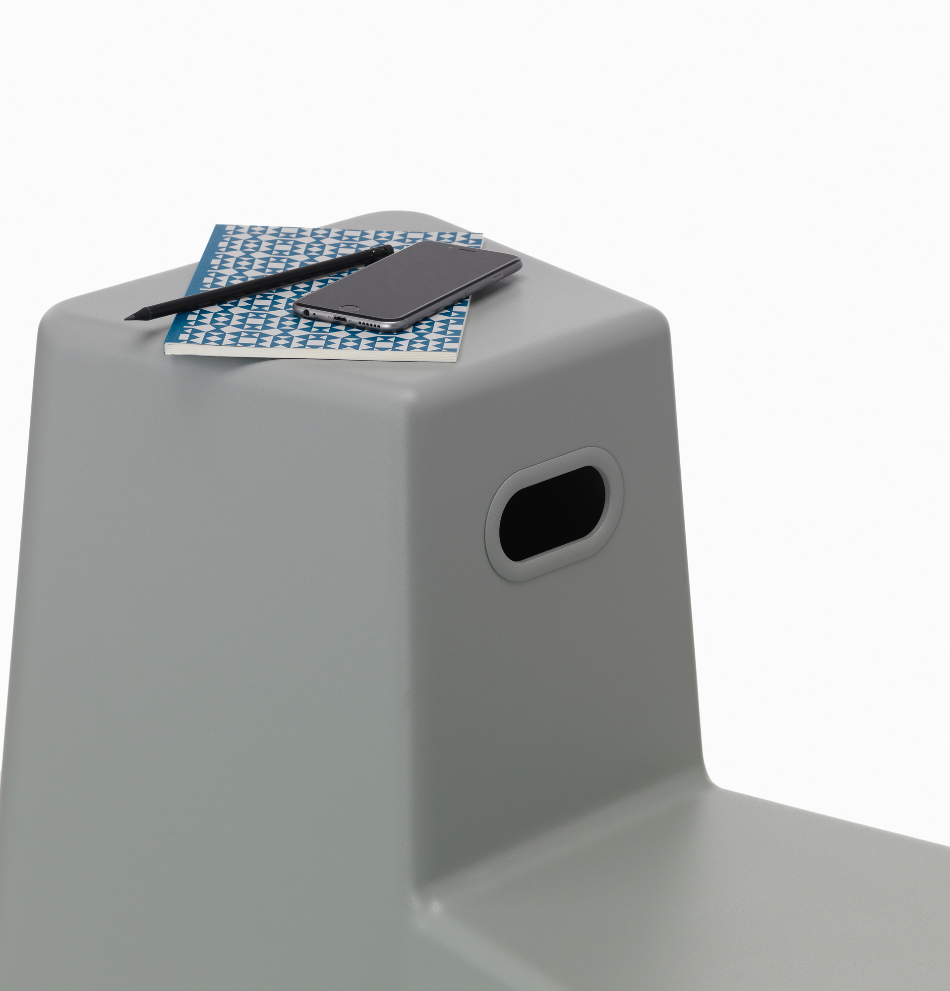 Grauer Stool Tool Stuhl von Vitra mit Notizblock, Stift und Smartphone. Modernes Möbeldesign.