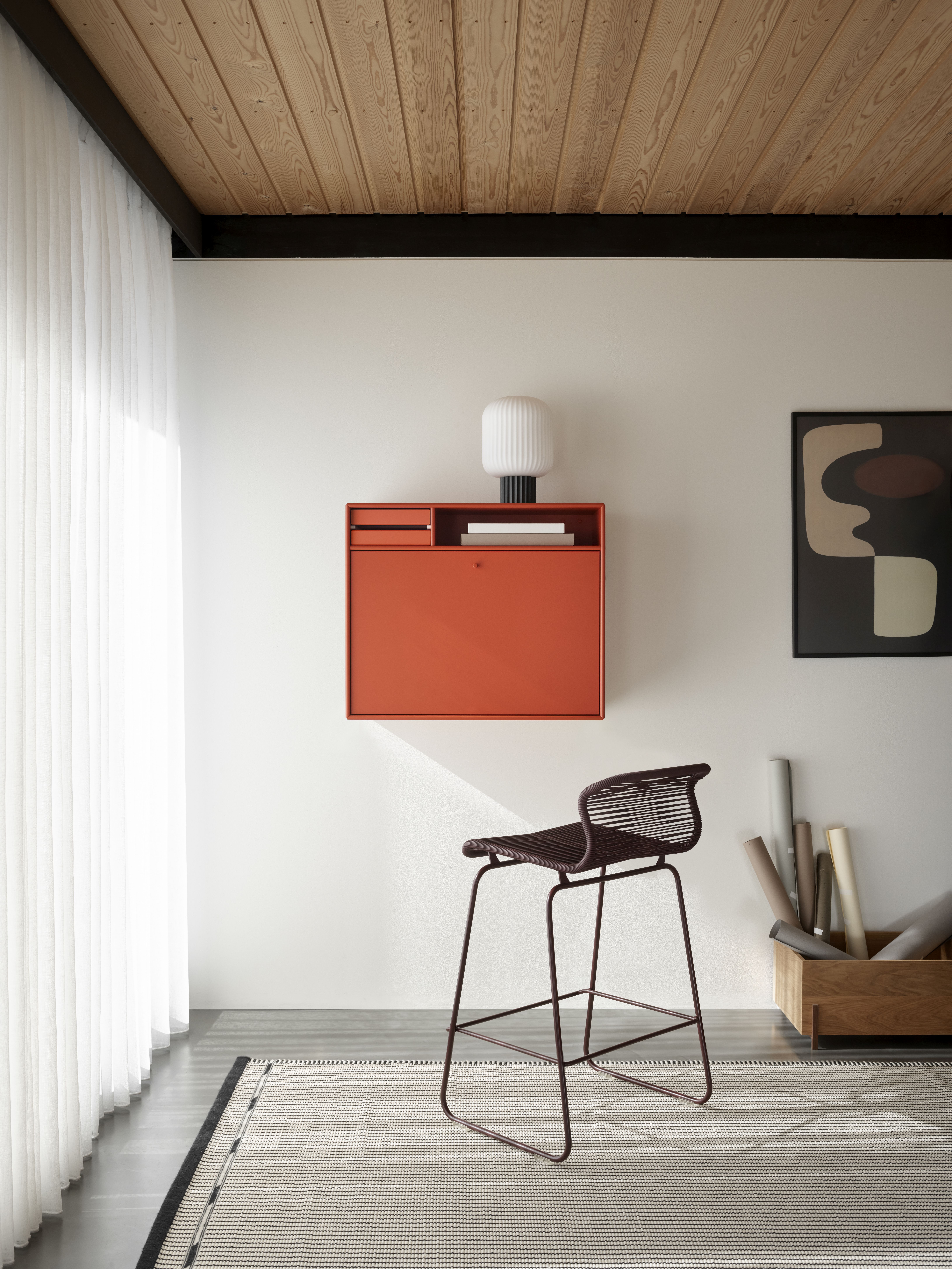 Moderner STUDIO Sekretär in Orange an der Wand mit Barstuhl und minimalistischem Design.