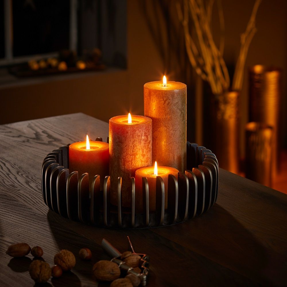 Bilbao Schale von Philippi mit vier brennenden Kerzen in warmen Farben auf dunklem Holztisch.