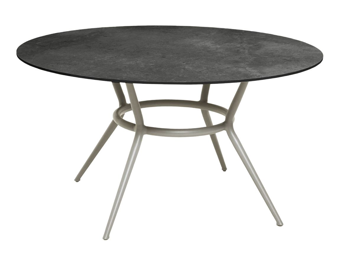 Runder Joy Outdoor Esstisch von Cane-Line mit taupefarbenem Gestell und dunkler Tischplatte.