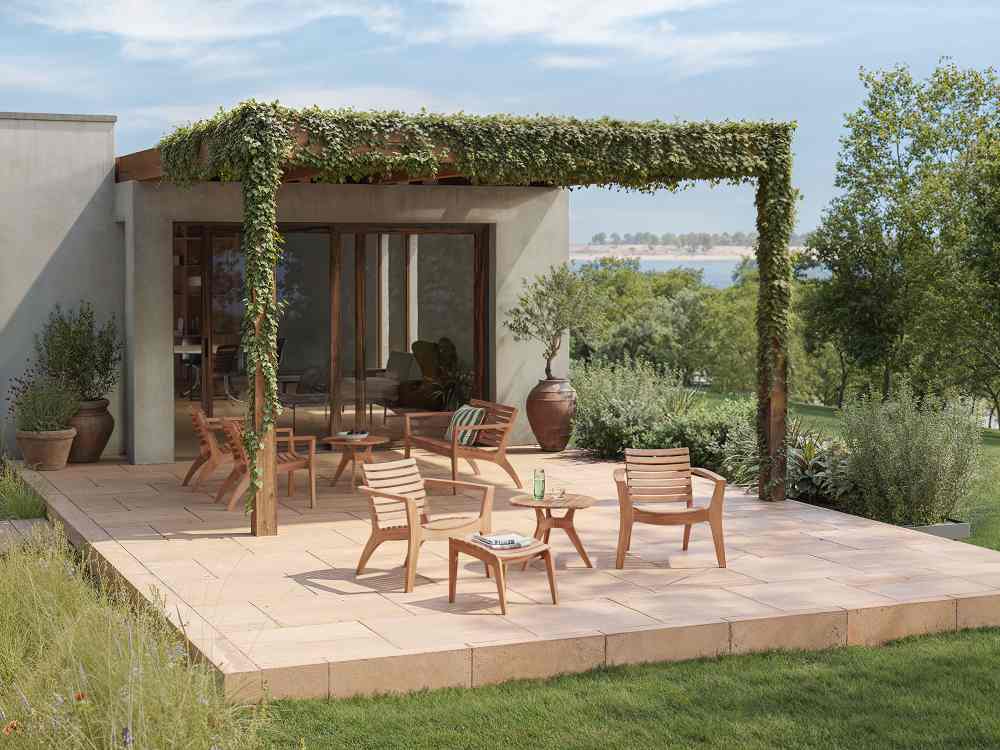 Outdoor-Szene mit Skagerak Tisch und Stühlen von Fritz Hansen auf einer sonnigen Terrasse.