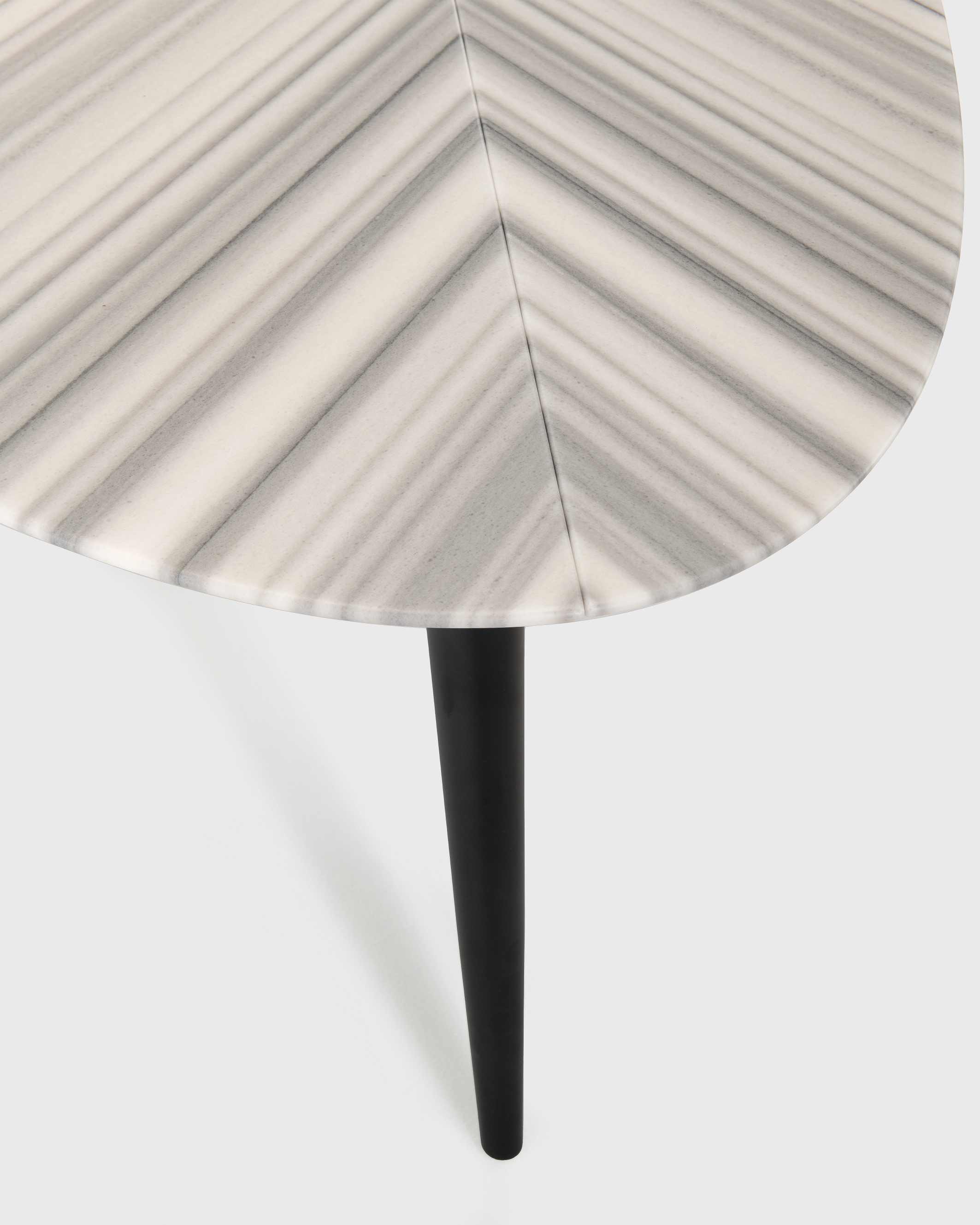 Detailaufnahme des Zanotta 2318 Tweed Marble Esstischs mit Marmorplatte und schwarzen Beinen.