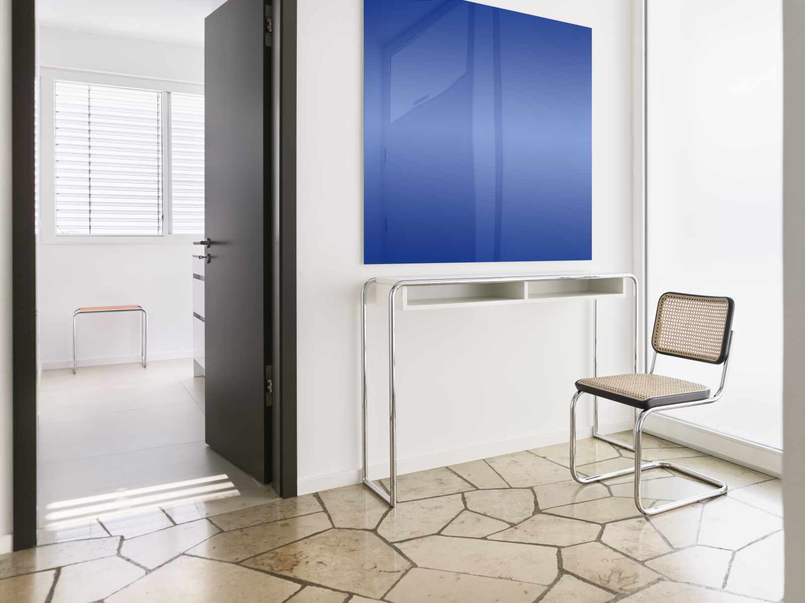 B 108 Thonet Konsolentisch aus Stahlrohr, kombiniert mit einem passenden Stahlrohrstuhl und blauer Wandkunst.