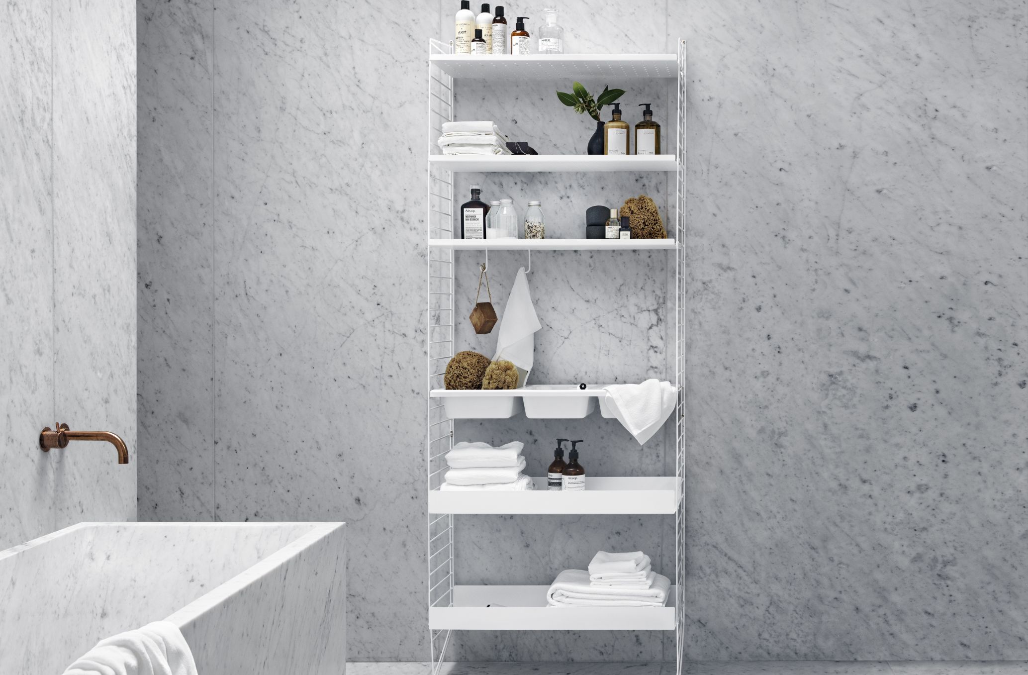 Weißes String Regal, Bodenleiter H 200 cm, im Badezimmer mit Handtüchern und Pflegeprodukten.