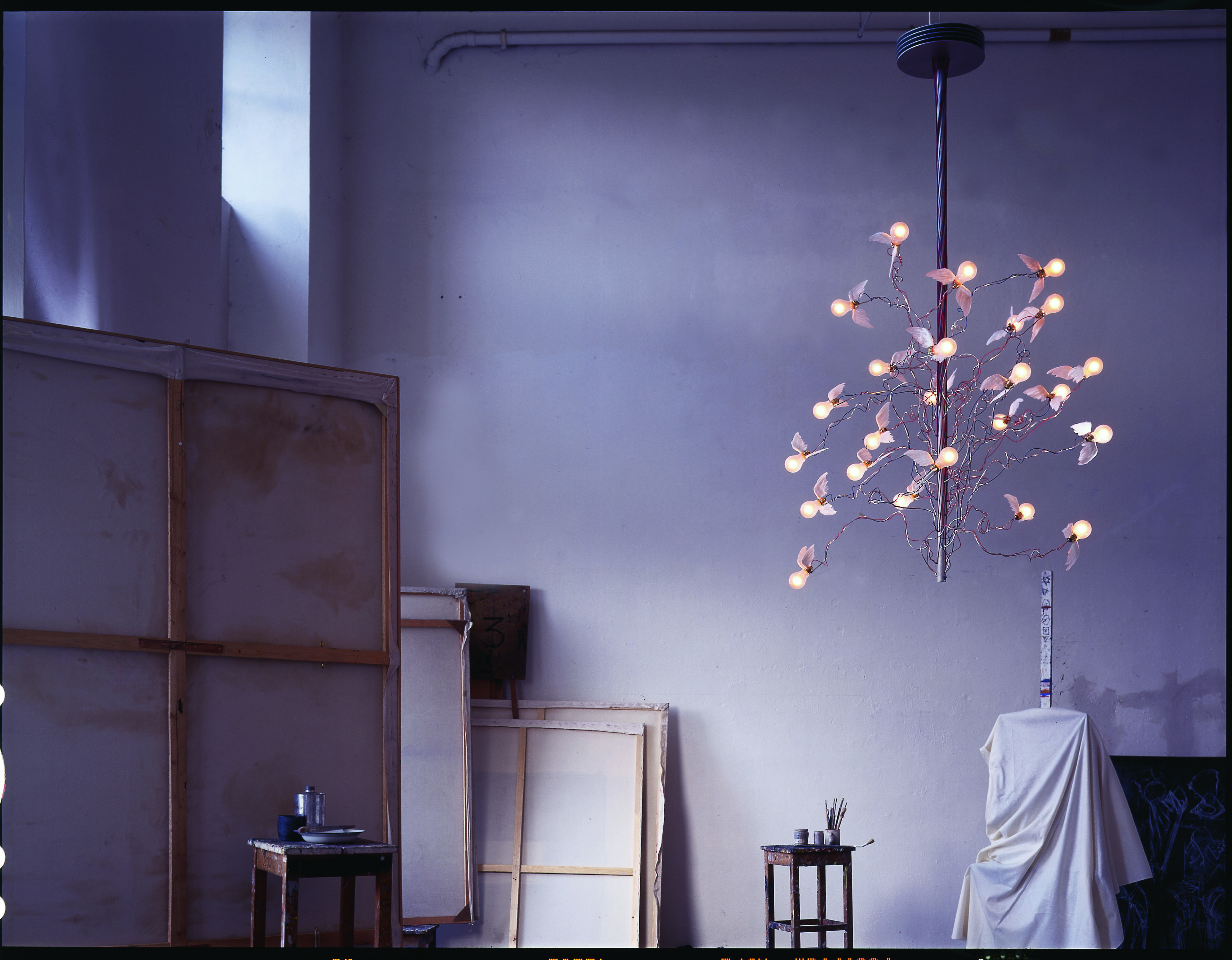 Birds Birds Birds Kronleuchter von Ingo Maurer: Hängelampe mit Glühbirnen und kleinen Flügeln im Atelier.