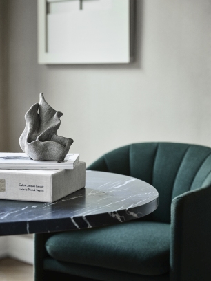 Detailaufnahme: Grüner Loafer Sessel von AndTradition mit Marmortisch und Deko-Objekt. Design Sessel für Wohnzimmer.