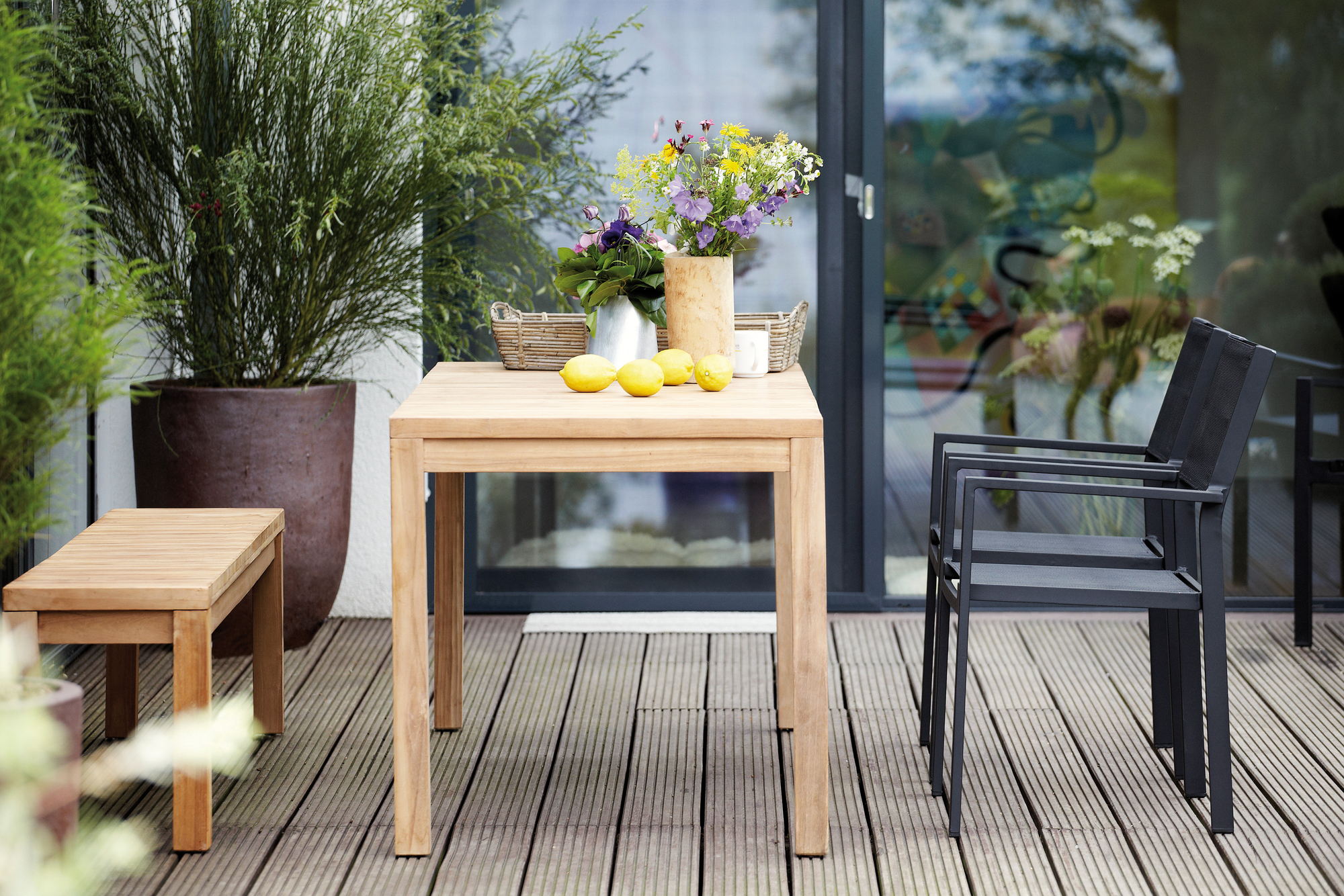 Samoa Tisch Natur von Jan Kurtz, Breite 75 cm, aus Teakholz auf einer Terrasse.