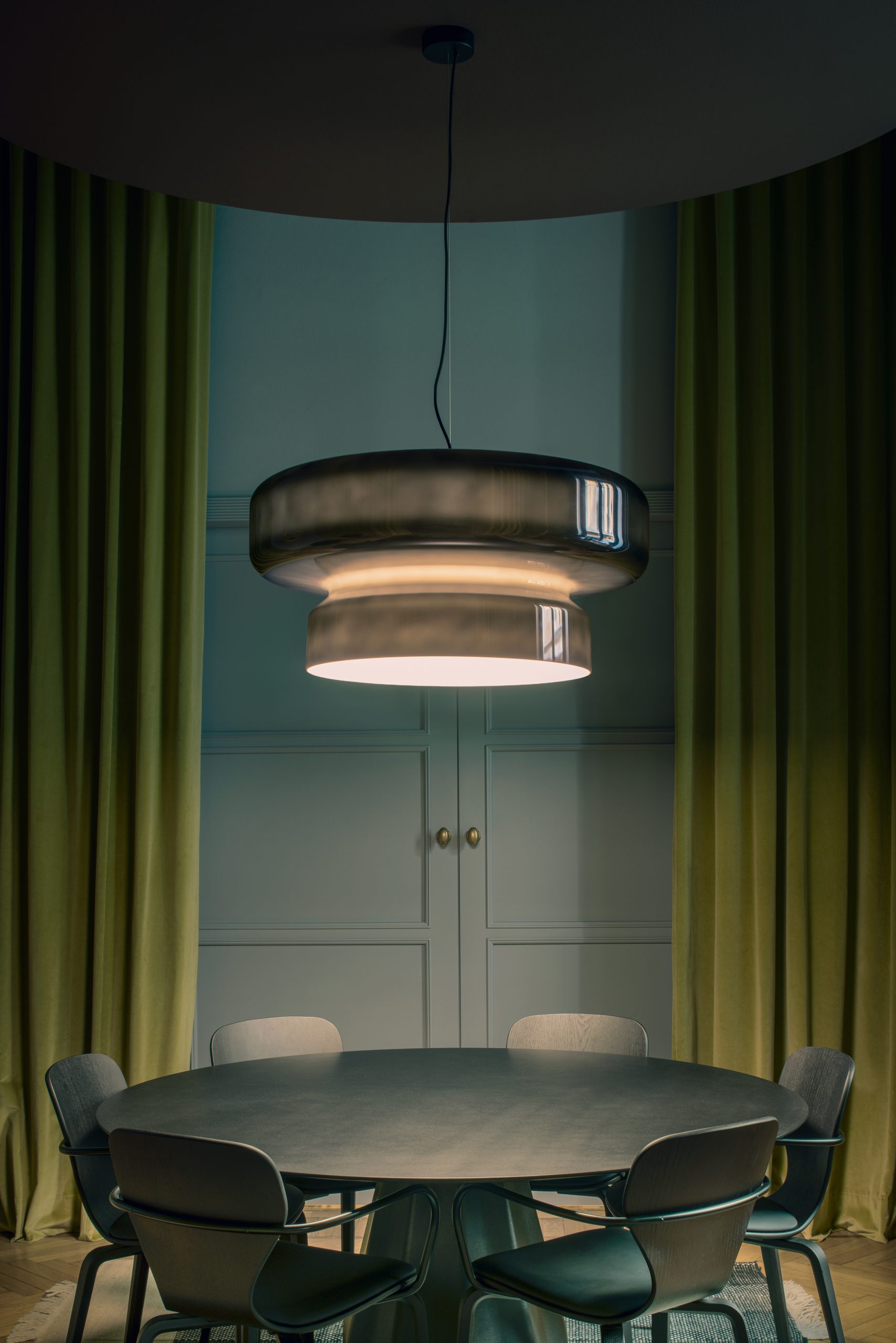 Bohemia Pendelleuchte von Marset in Rauchgrau über Esstisch mit Stühlen. Designlampe.