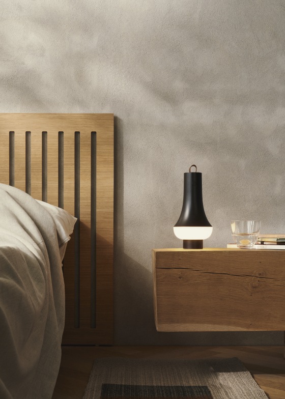 Tomoshi Akkuleuchte von Louis Poulsen in Dunkelbraun auf einem Nachttisch im Schlafzimmer.