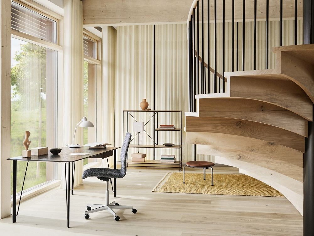Schwarzer Fritz Hansen Schreibtisch FH3605™ ohne Schublade in modernem Büro mit Stuhl und Treppe.