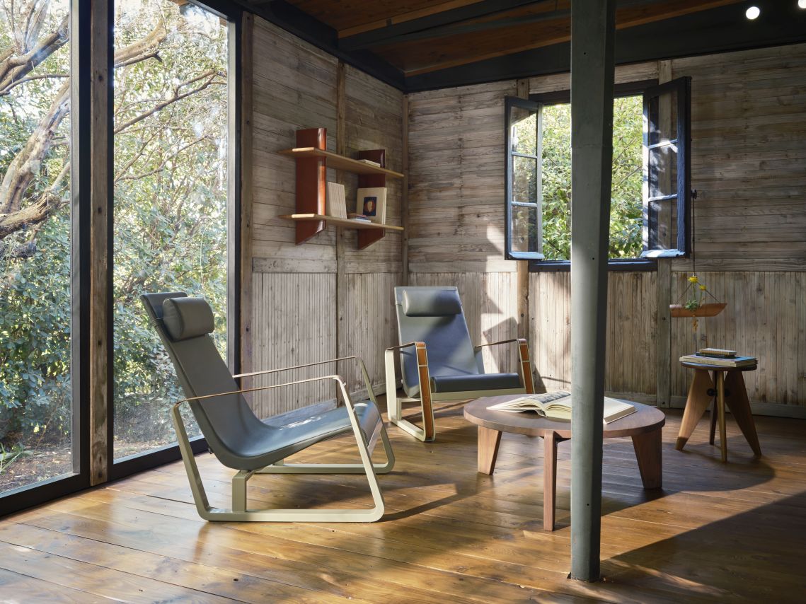 Innenaufnahme mit Vitra Wandregal Rayonnage Mural, Stühlen und Tisch in rustikalem Raum.