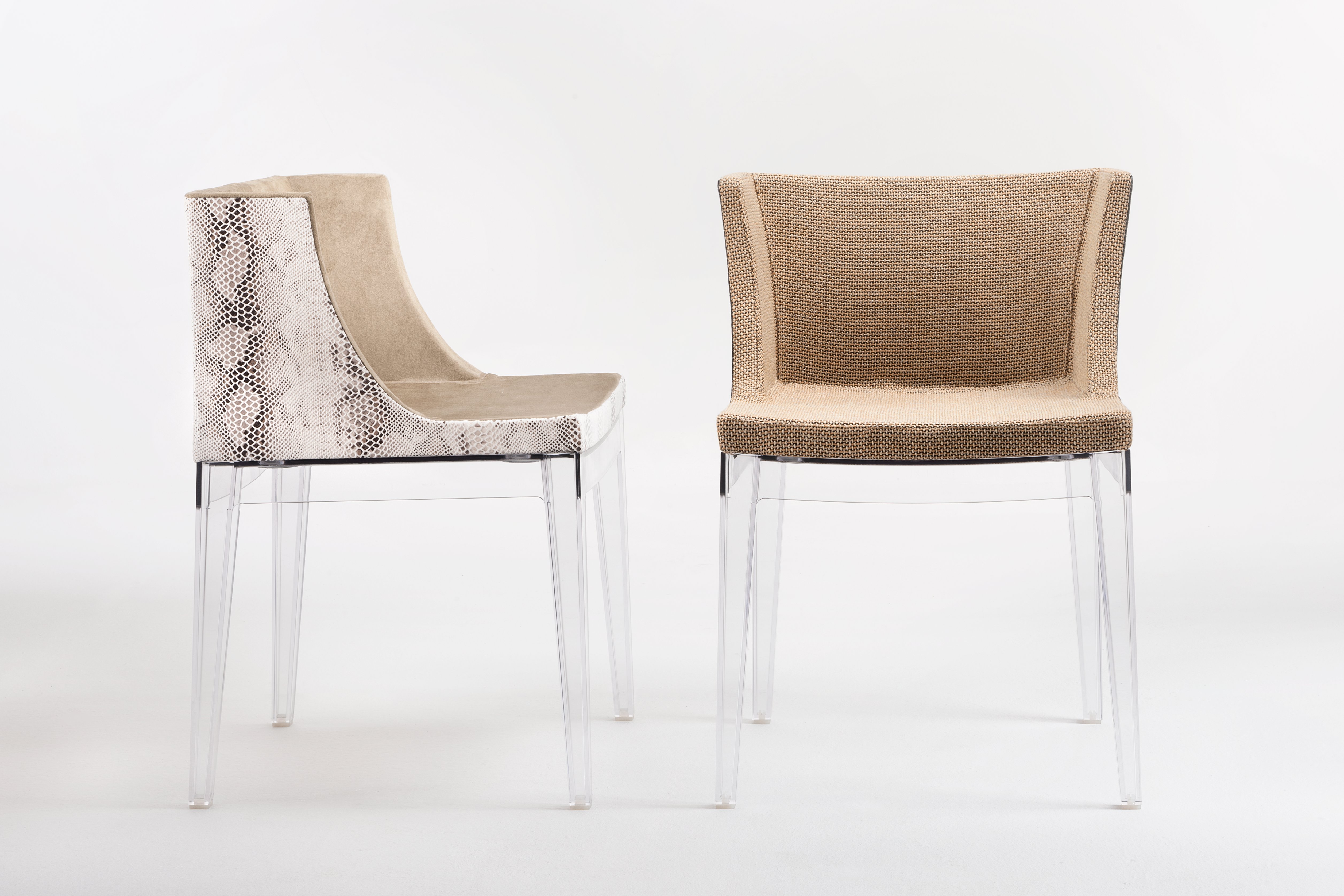 Zwei Mademoiselle Stühle von Kartell mit transparenten Beinen und unterschiedlichen Bezügen.
