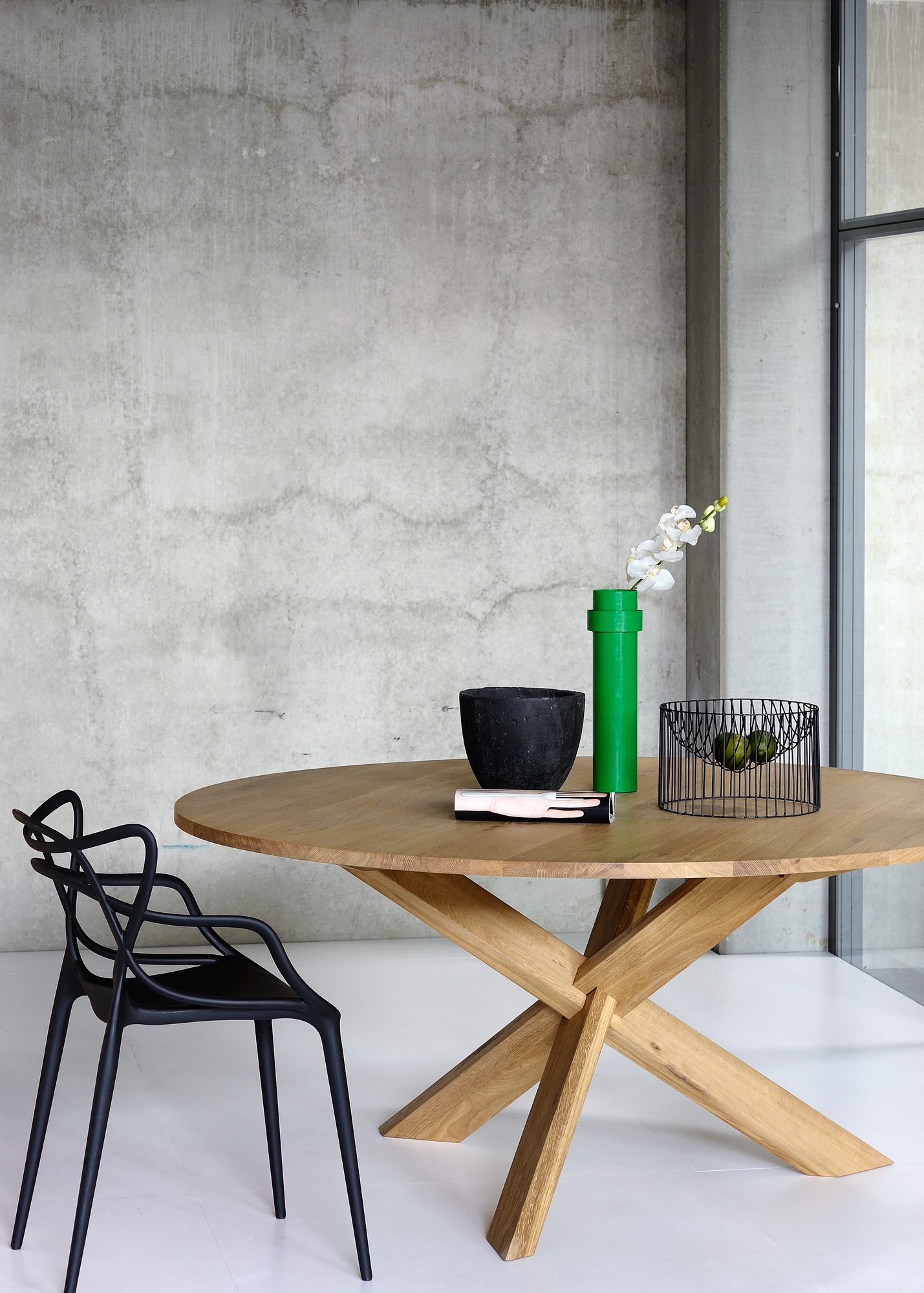 Esstisch Circle Eiche Ethnicraft: Runder Holztisch mit modernem Design und dekorativen Elementen im Esszimmer.