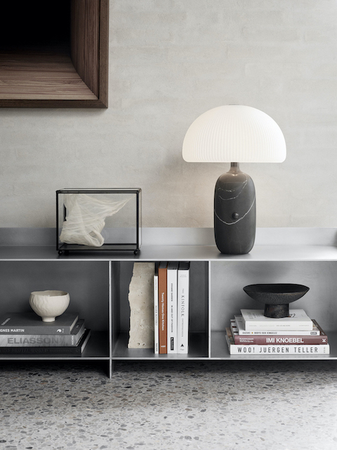 Nahaufnahme der Vipp Sculpture Tischlampe mit Marmorfuß und plissiertem Schirm auf einem Regal.