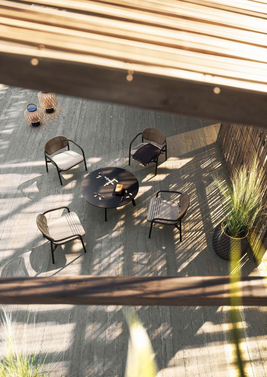 Draufsicht: SeaX Armchair Armlehnstühle von Dedon um einen runden Tisch im Außenbereich.