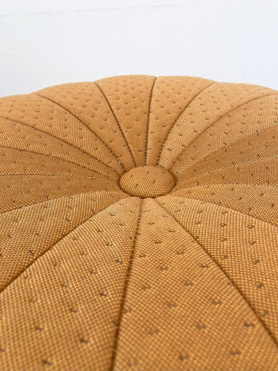 Detailaufnahme des Claudie Pouf Hockers von Hartô in Senfgelb mit Knopf und gestepptem Muster.