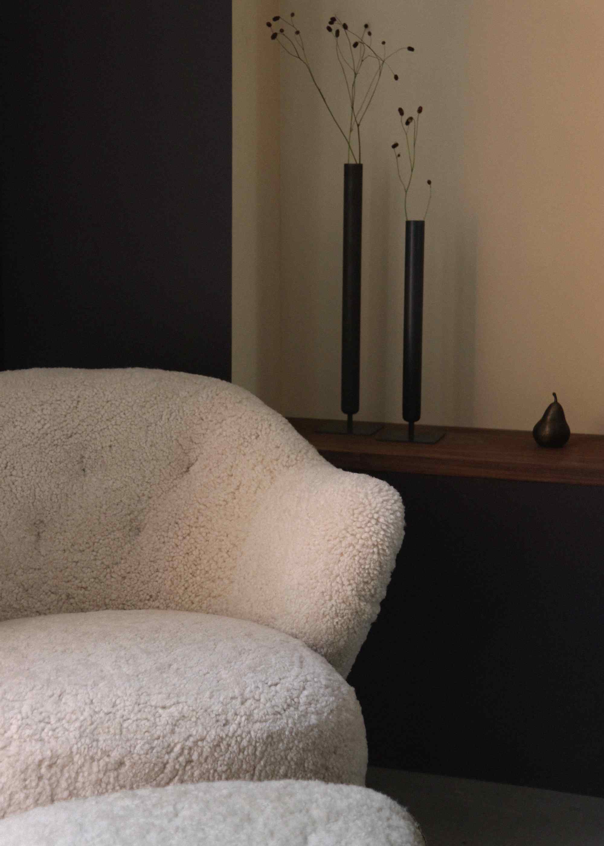 Detailaufnahme des Ingeborg Ottoman Audo mit cremefarbenem Bouclé-Bezug, stilvolles Sitzmöbel für Wohnzimmer und Lounge.