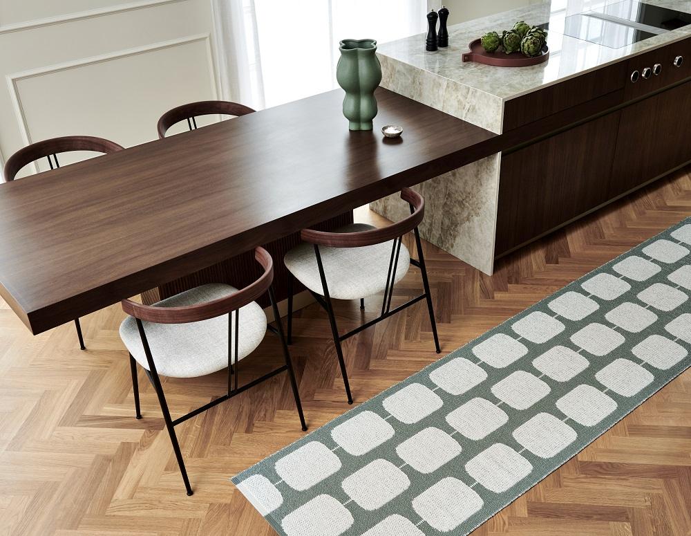 Sten Kunststoffteppich in Ochre/Vanille von Pappelina im Raum, rechteckiges Muster, pflegeleichter Teppich für Küche und Esszimmer.