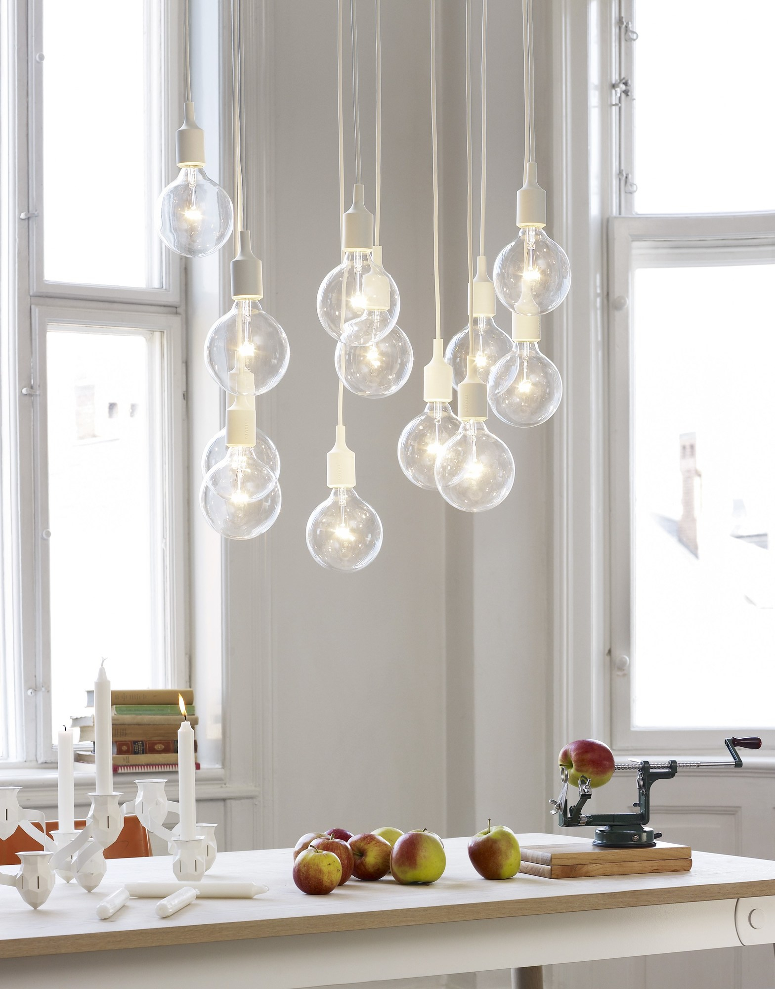 The More the Merrier Kerzenhalter von Muuto in Weiß, mit brennenden Kerzen auf einem Tisch.