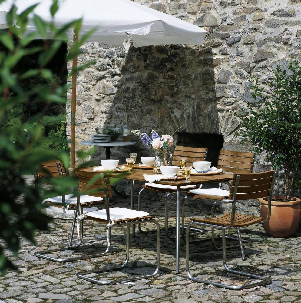 S 1040 Gartentisch von Thonet mit Stühlen im Freien, gedeckt für ein Essen.