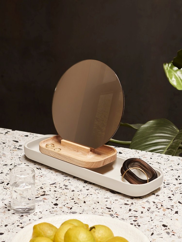 Slide Aufbewahrungseinheit von Fritz Hansen: Elegante Ablage mit Spiegel, Holztablett und Schmuck auf Terrazzo.