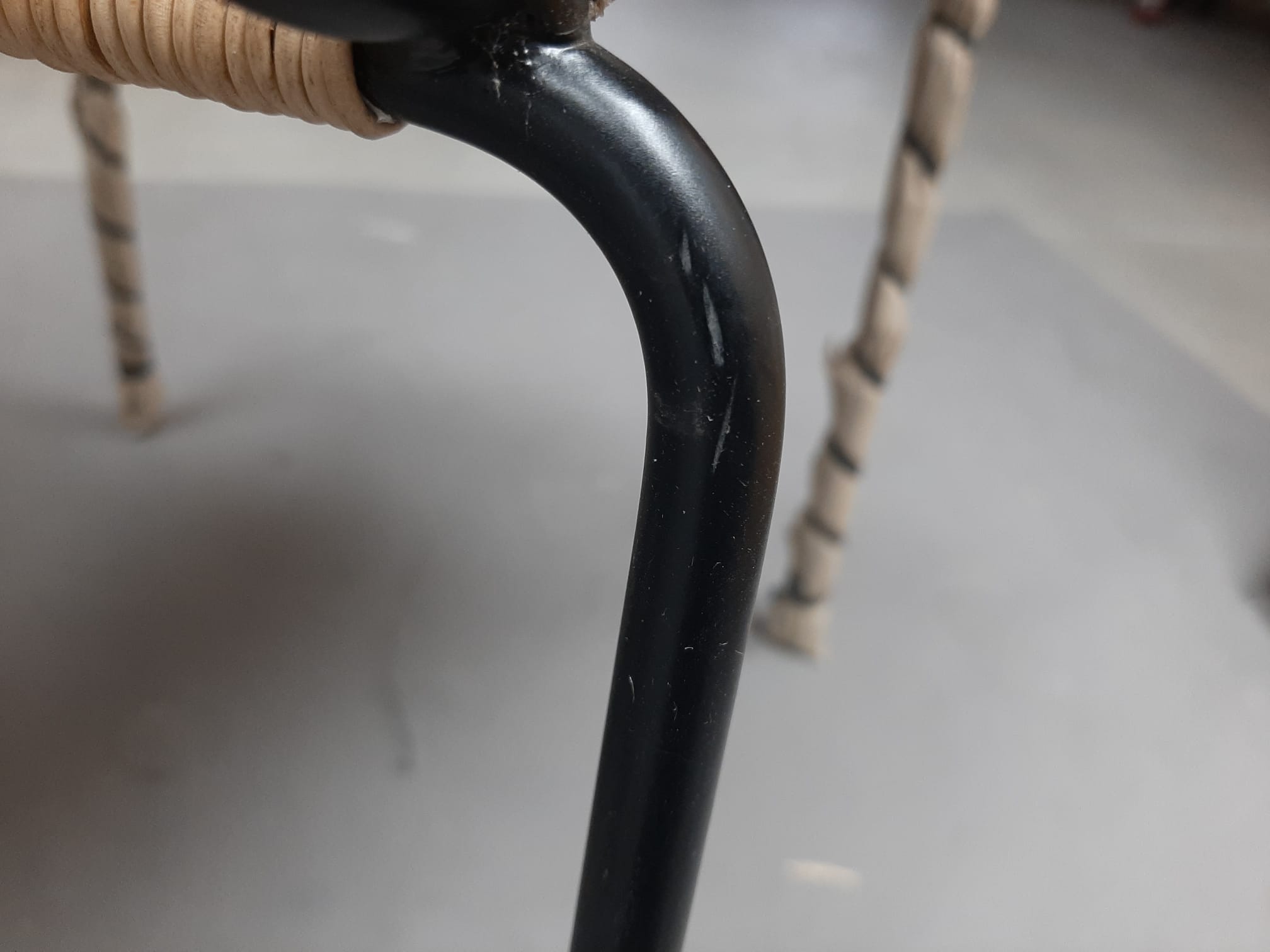 Detailaufnahme des Stuhlbeins vom Stuhl TT 54 (Mängelexemplar) mit Kratzern im schwarzen Metall.