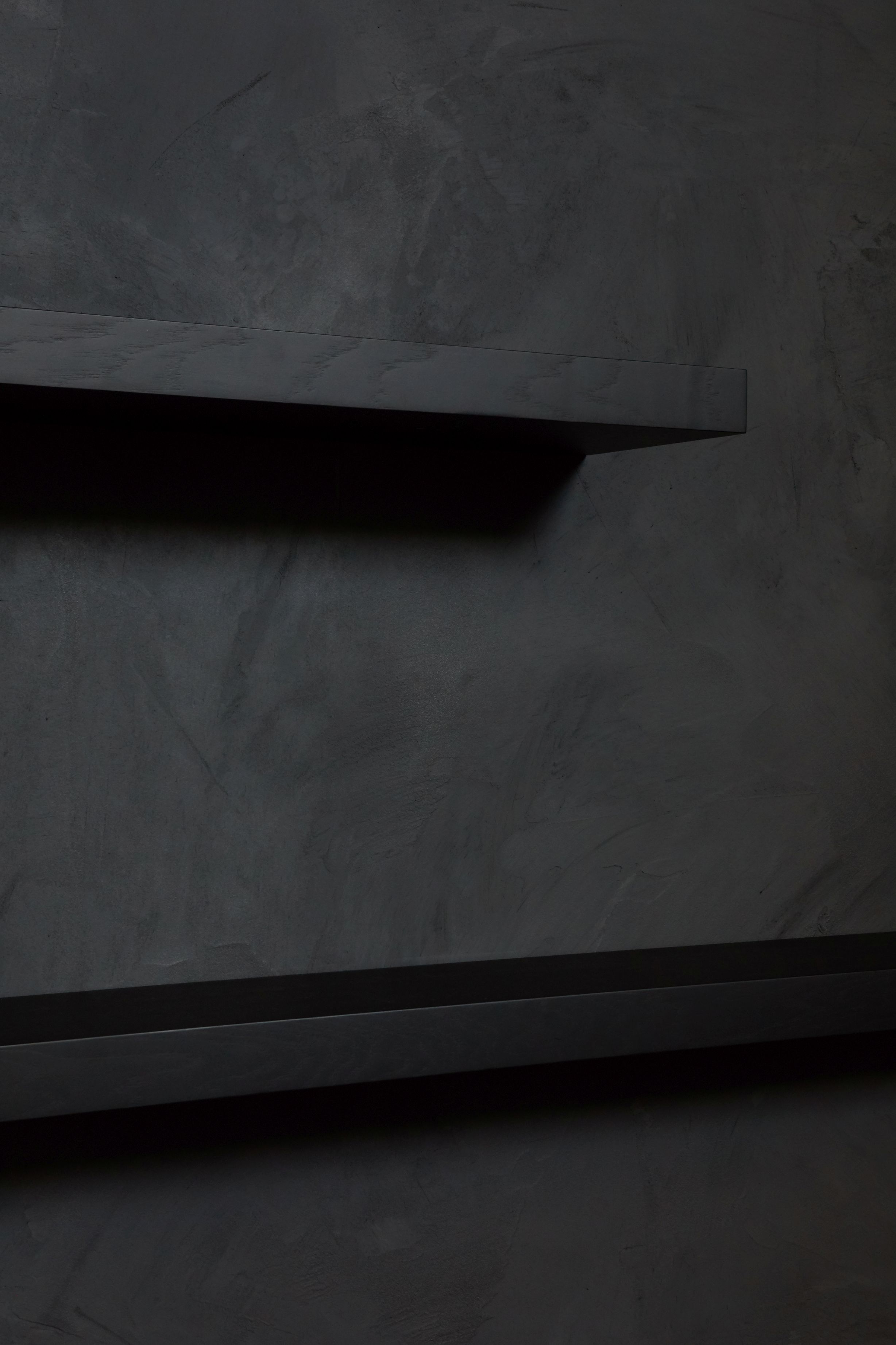 Zwei schwebende, schwarz lackierte Wandregale aus Eiche von Ethnicraft vor einer dunklen Wand.