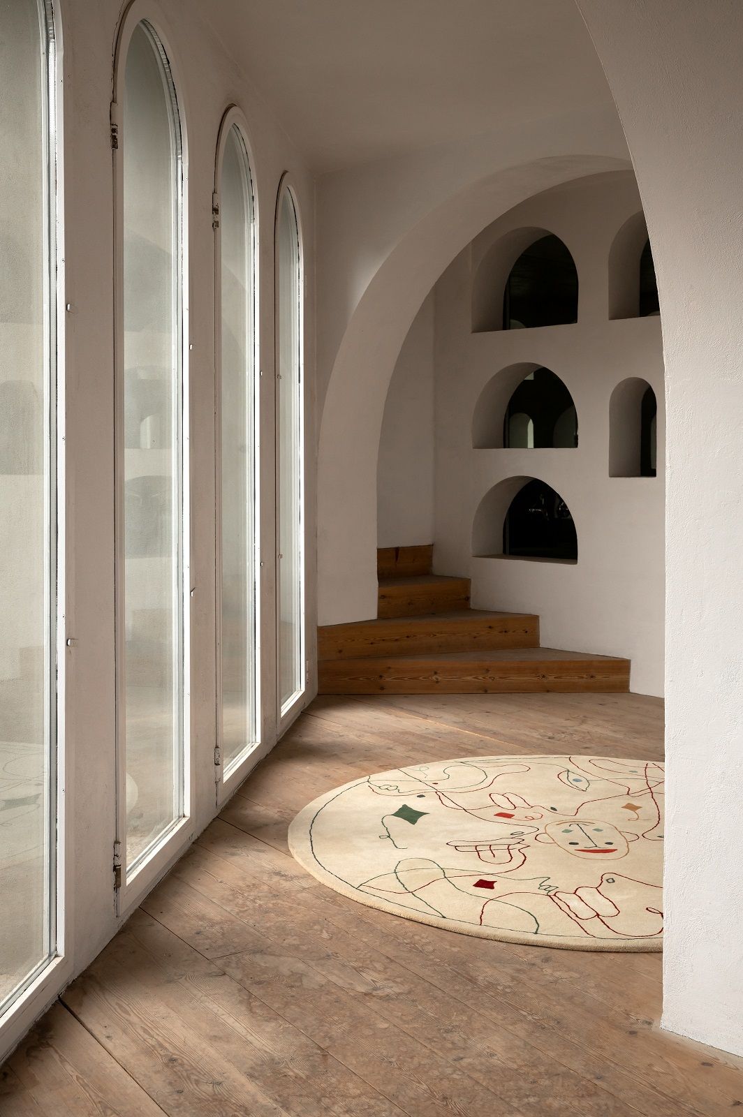 Runder Silhouette Teppich von Nanimarquina in hellem Raum mit Holzboden und Fensterfront.