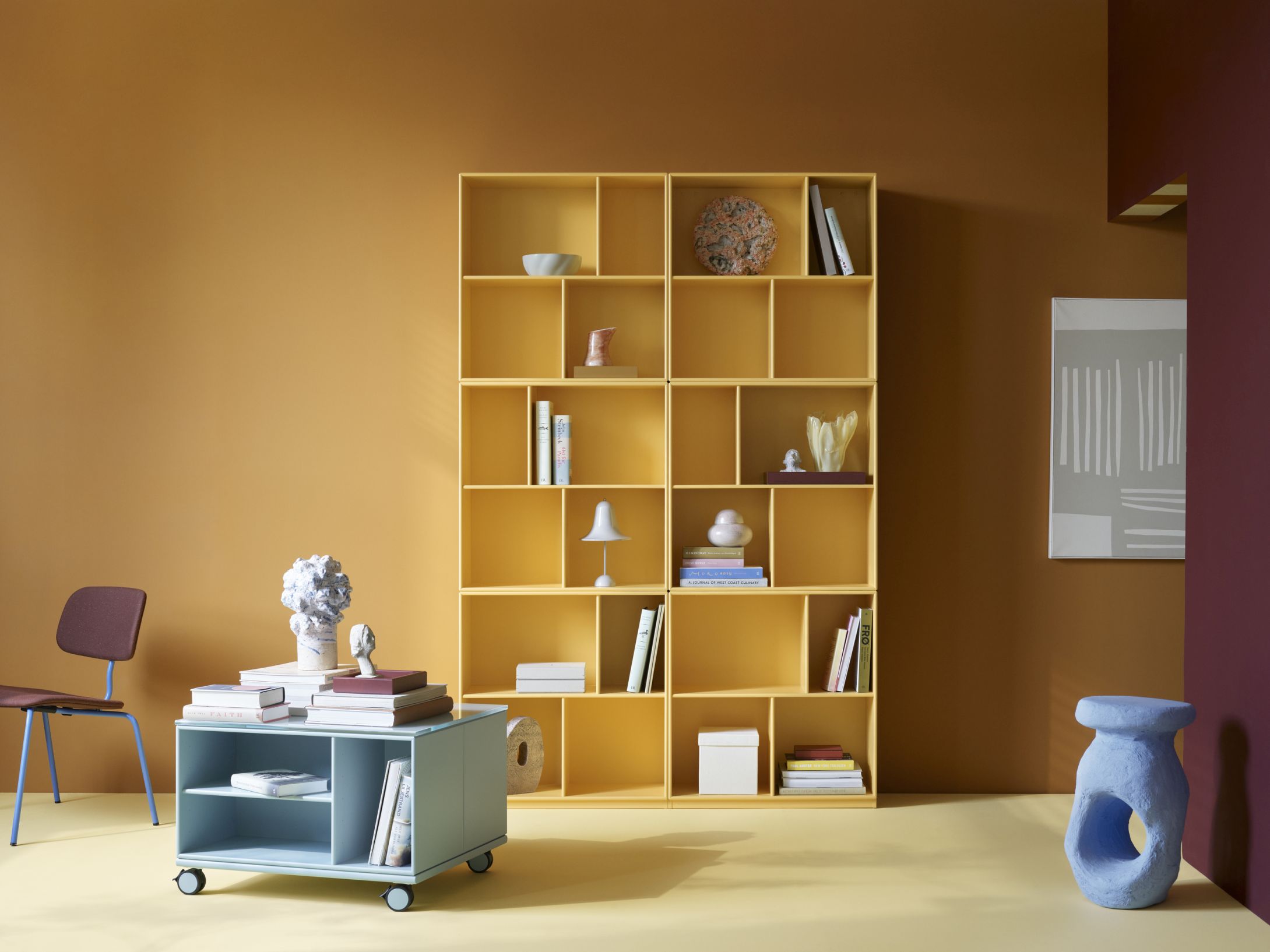 Gelbes Read Bücherregal von Flint Montana, gefüllt mit Büchern und Deko-Objekten. Modernes Regalsystem für Wohnzimmer.