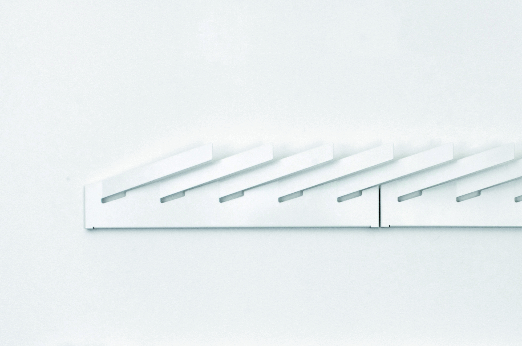 Weißer Mr_Magazinhalter Linea1 von Müller Möbelwerkstätten an einer weißen Wand. Modernes Design für Zeitschriften und Magazine.