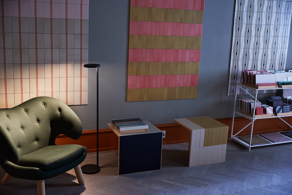 Moderne Flos Oblique Stehleuchte in Braun matt im Interieur mit Sessel und Fliesen.